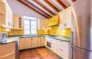 a kitchen with white cabinets and a stainless steel refrigerator at Awesome Home In Rincón De La Victoria in Rincón de la Victoria