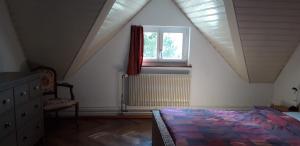 um quarto no sótão com uma cama e uma janela em Ferienwohnung Stein am Rhein Nahe Bahnhof und Rhein em Stein am Rhein