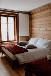 a bedroom with a large bed with a wooden wall at Residence Kalipè in Alagna Valsesia