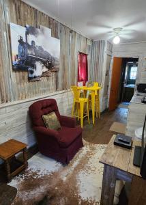 a living room with a couch and a train painting on the wall at The Carson House Bed & Breakfast in Pittsburg