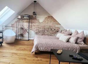 a bedroom with a bed and a brick wall at Ferienloft Ottos Werkstatt mit Saunafass in Dannenfels