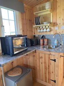 a kitchen with a microwave and a sink at Beautiful 1 Bed Shepherd Hut in Warwickshire in Warwick