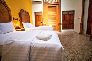 a hotel room with two beds with towels on them at Hotel Real Toledo by Kavia in Mérida