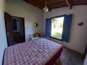 una camera con un letto e una grande finestra di Cabana na Serra do Itaqueri com fogão a lenha e churrasqueira a Itirapina
