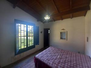 una camera con letto e finestra di Cabana na Serra do Itaqueri com fogão a lenha e churrasqueira a Itirapina