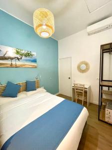 ein Schlafzimmer mit einem großen Bett und einer blauen Wand in der Unterkunft Pensión Bertolín in Barcelona