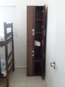 ein Bücherregal in einem Zimmer neben einem Bett in der Unterkunft casa de praia campos in Itanhaém