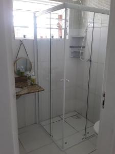 a shower with glass doors in a bathroom at casa de praia campos in Itanhaém