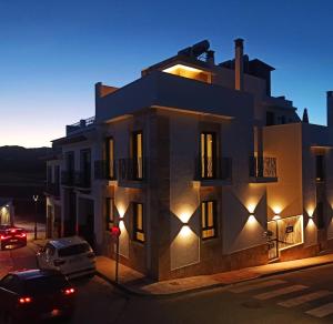 un bâtiment avec des lumières sur son côté dans l'établissement APTOS MILLÁN, à Ardales