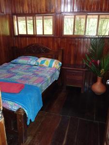 a bedroom with a bed in a wooden cabin at casa en el parque tayrona in Santa Marta