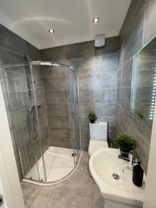 uma casa de banho com um chuveiro, um WC e um lavatório. em Beautiful Studio flat em Purley