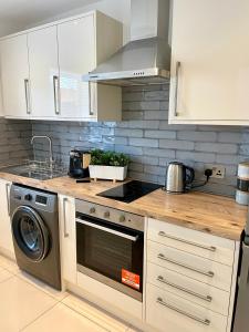 a kitchen with a stove top oven next to a dishwasher at Beautiful Studio flat in Purley