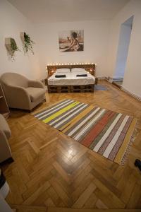 um quarto com uma cama, um sofá e um tapete em Casa Boemia em Braşov
