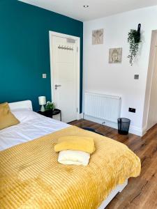 a bedroom with a bed with a yellow blanket at Beautiful Studio flat in Purley