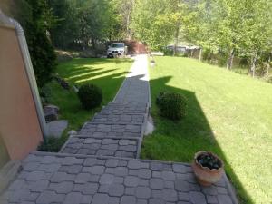 a brick walkway leading to a yard with a lawn at Demény vendégház in Sub Cetate
