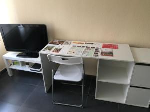 escritorio blanco con TV y monitor en Apartamento Haro Wine Experience, en Haro