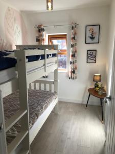 謝菲爾德的住宿－Sheffield 3-bedroom house with free street parking，一间卧室设有两张双层床和一张桌子