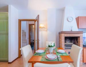 a dining room with a table and chairs and a fireplace at [Siena] Appartamento con splendido terrazzo in Presciano
