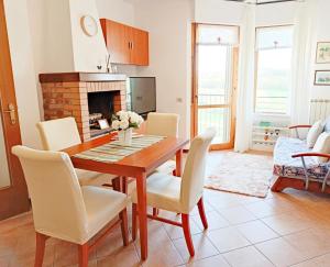 eine Küche und ein Esszimmer mit einem Holztisch und Stühlen in der Unterkunft [Siena] Appartamento con splendido terrazzo in Presciano
