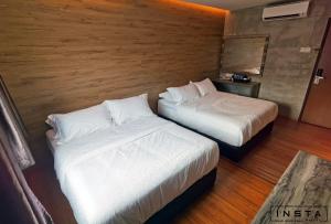 a hotel room with two beds and a mirror at Insta Hotel JB in Johor Bahru