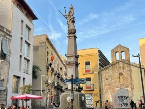eine Statue an einem Mast in der Mitte einer Straße in der Unterkunft Pensión Bertolín in Barcelona