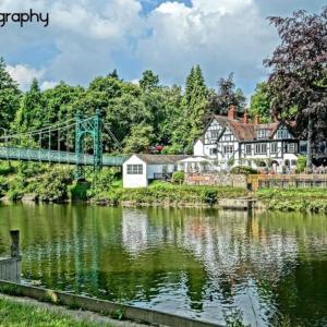 a bridge over a river with houses and trees at Georgian 3 bed house in historic town centre in Shrewsbury