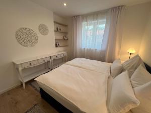 1 dormitorio con cama blanca y ventana en Haus am Wanderweg en Melk