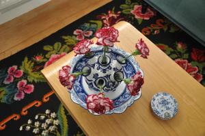 a blue and white plate with red flowers on a table at Himelsk in Koudum