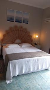 uma cama grande com uma cabeceira em madeira num quarto em Ilha Flat Hotel Suíte Bella - 4207 - Ilhabela em Ilhabela