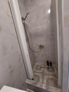ein Bad mit einer Dusche und Fliesenboden in der Unterkunft HaKhanh family in Prag