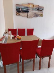 einem Esstisch mit roten Stühlen und einem Gemälde in der Unterkunft HaKhanh family in Prag