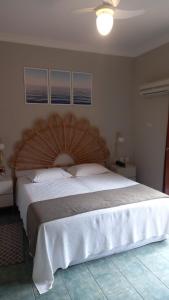 - un grand lit avec une grande tête de lit en bois dans une chambre dans l'établissement Ilha Flat Hotel Suíte Bella - 4207 - Ilhabela, à Ilhabela