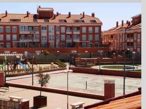 un parque con parque infantil frente a un edificio en La Casa del impresor, en Ávila