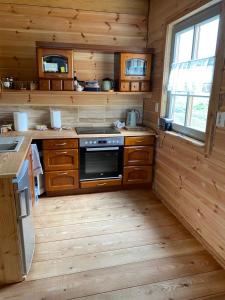 a kitchen with wooden cabinets and a stove top oven at Gabel&Jurgen in Mirsk