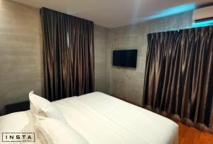 1 dormitorio con cama blanca y ventana en Insta Hotel JB en Johor Bahru