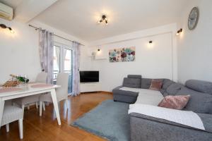 un soggiorno con un divano e un tavolo di Apartmani Nina & Mili a Igrane
