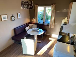 a living room with a table and a couch at T Huuske tuinappartement met fantastisch uitzicht, nabij Zee in Zonnemaire