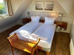 a bedroom with two beds and a wooden bench at ’t Huuske in Zonnemaire