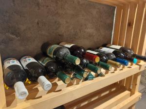 a bunch of wine bottles on a wooden shelf at Udahni prirodu in Raška