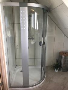 a shower with a glass door in a bathroom at ’t Huuske in Zonnemaire