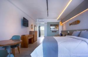 a bedroom with a large white bed and a wooden table at Hotel Village Enseada in Ubatuba