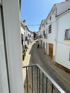 um cão a andar numa rua com edifícios em Mirador del farmacéutico em Zahara de la Sierra