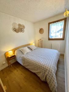 a bedroom with a bed and a window at Au Petit Flocon - Appartement 3 pièces, central et proche pistes - parking privé et wifi in Megève