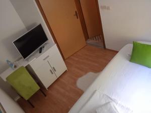 a small room with a bed and a television at Villa Monera Apartments & Rooms & Free Garage in Mostar