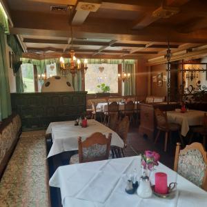 un restaurante con mesas y sillas blancas y un comedor en Landgasthaus Birkegg, en Leutasch