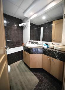 La salle de bains est pourvue d'un lavabo et d'un grand miroir. dans l'établissement Fabolous Vacation Home in Dubai Marina, à Dubaï