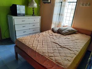 um quarto com uma cama com uma cómoda e uma janela em Villas Karen em Tonsupa