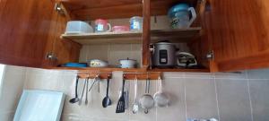 a kitchen with wooden cabinets and utensils on the wall at Villas Karen in Tonsupa