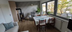 ein Wohnzimmer mit einem Tisch, Stühlen und einem Kamin in der Unterkunft gemütliche Wohnung mit Kamin - Sunny Hill Holiday Home in Echternacherbrück