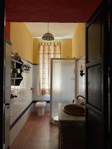 uma casa de banho com um lavatório, um WC e uma janela. em Mirador del farmacéutico em Zahara de la Sierra